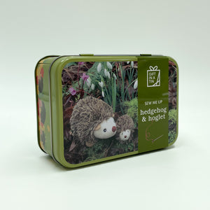 A green tin with a picture of a hedgehog and hoglet on the front.
